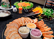 Mesa com cesta de pães, pastas variadas e decoração sofisticada - Rei dos Eventos