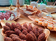 Mesa com salgados árabes como kibe, esfiha e patês - Rei dos Eventos