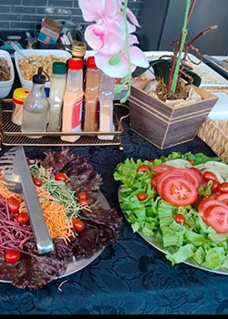 Buffet com saladas coloridas, arroz e acompanhamentos no evento com churrasco prata