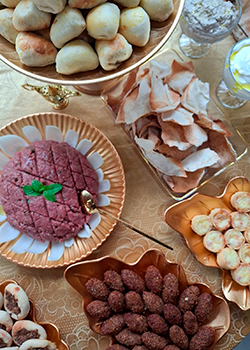 Kibe frito e esfiha em prato dourado no buffet árabe