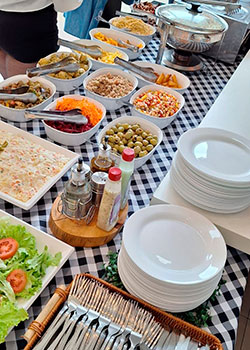 Mesa montada com pratos, talheres e acompanhamentos para o Buffet Churrasco Prata em domicílio
