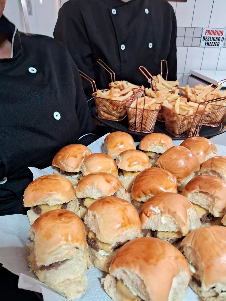 Mini hambúrguer e batata frita com equipe uniformizada do buffet infantil