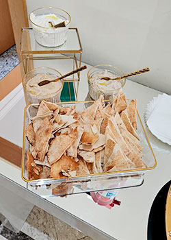 Pão sírio crocante servido com coalhada e homus